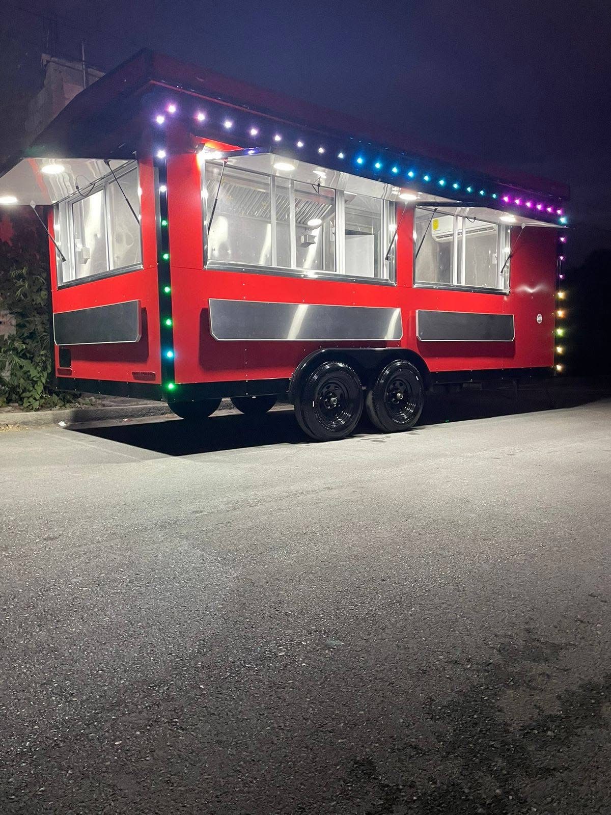 Red food trailer with LED lights at night